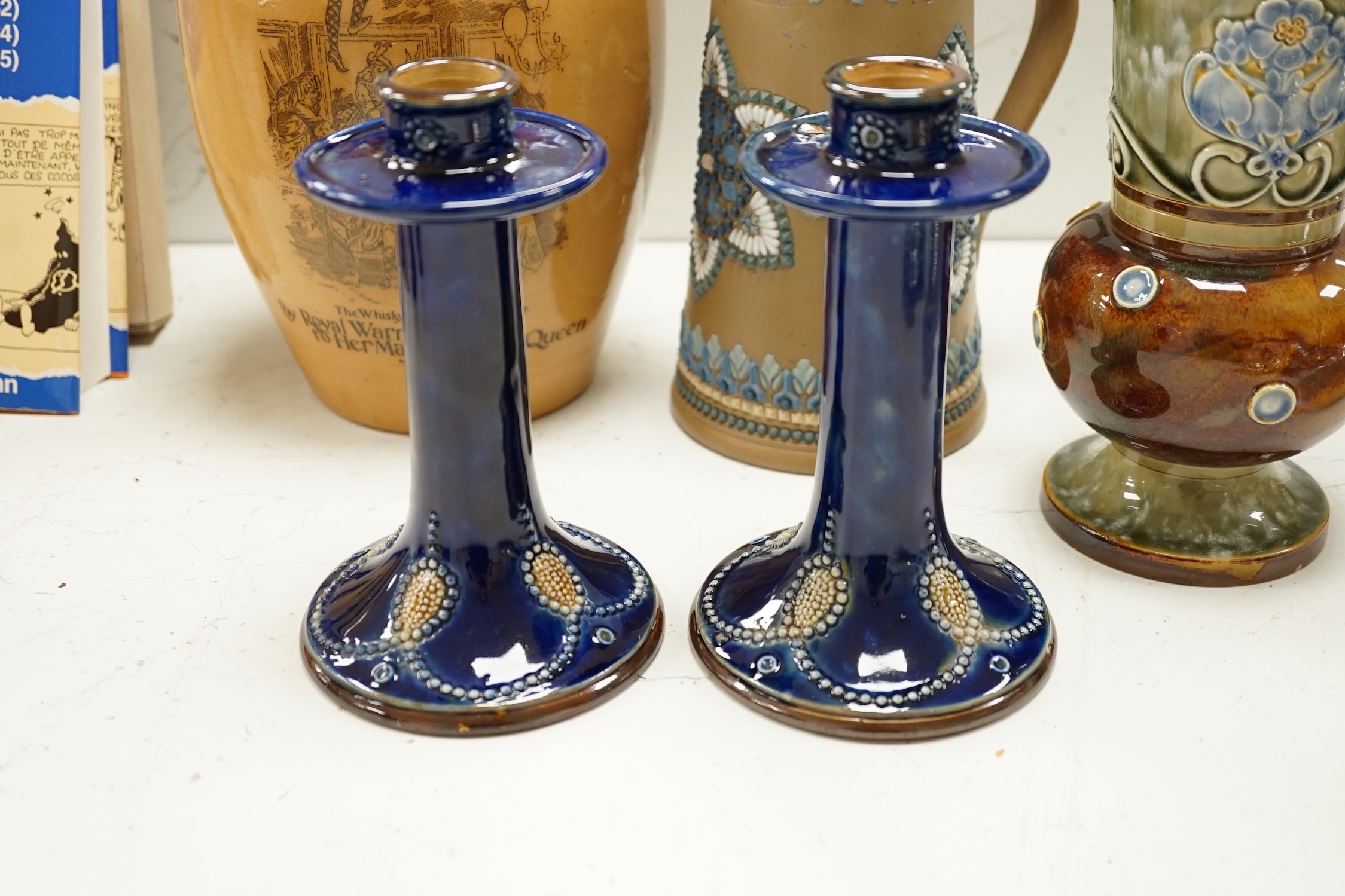 A Doulton Lambeth Dewars Perth whisky flagon, a pair of candlesticks and two other pieces, tallest 29cm. Condition - mostly good, one or two small chips